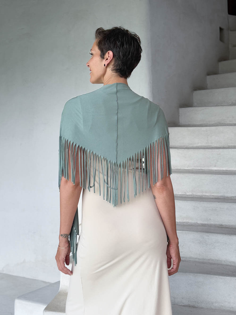 caraucci-fringe-scarf-sage-green-worn-as-shawl-over-cream-dress #color_moss