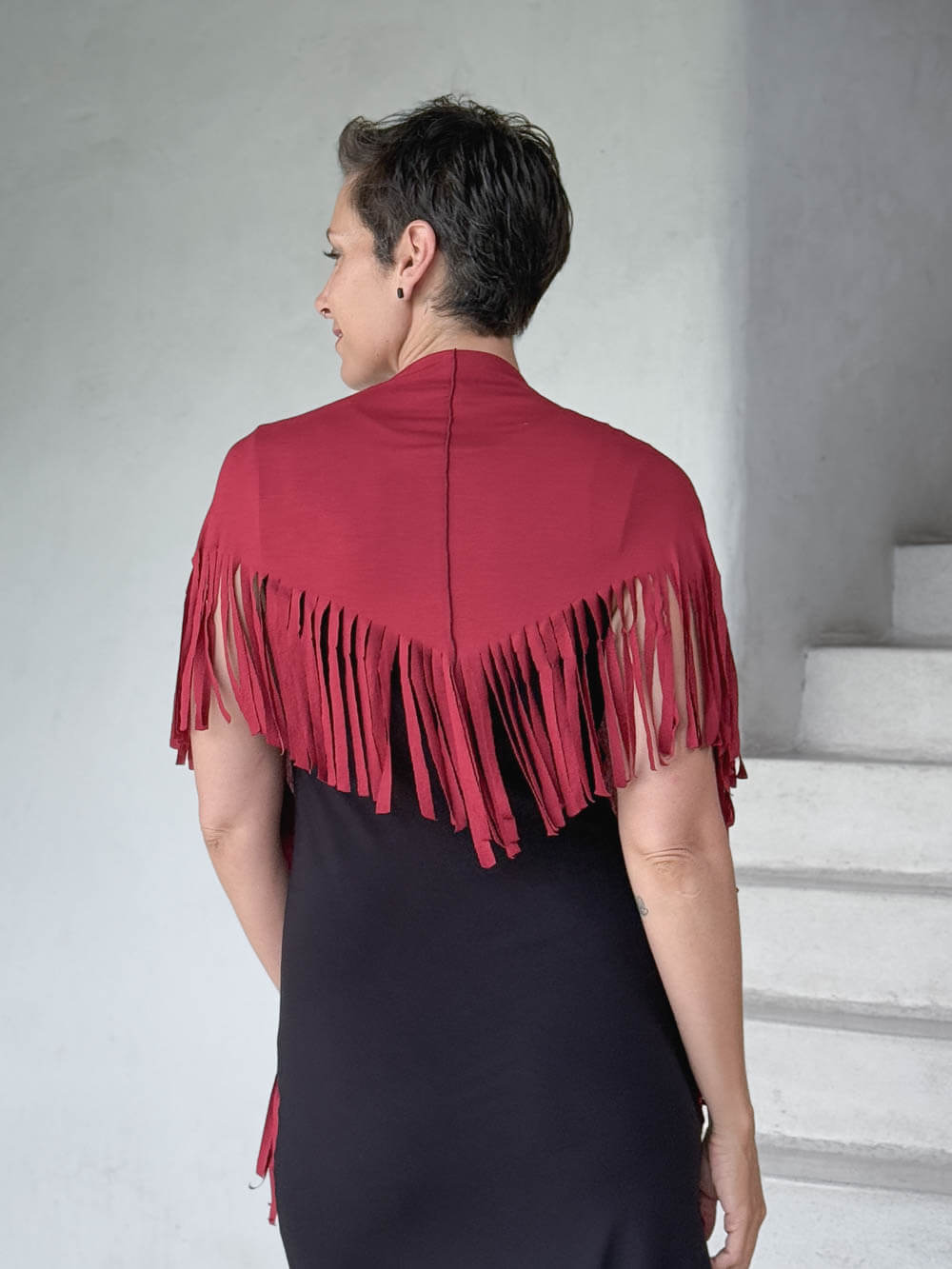caraucci-fringe-scarf-red-worn-as-shawl-over-black-dress #color_scarlet