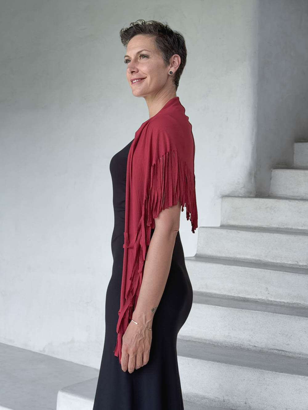 caraucci-fringe-scarf-red-worn-as-shawl-over-black-dress #color_scarlet