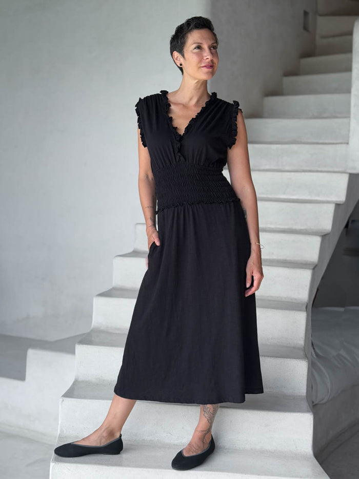 caraucci black midi-length dress with smocked waist and sleeveless ruffled neckline and pockets #color_black