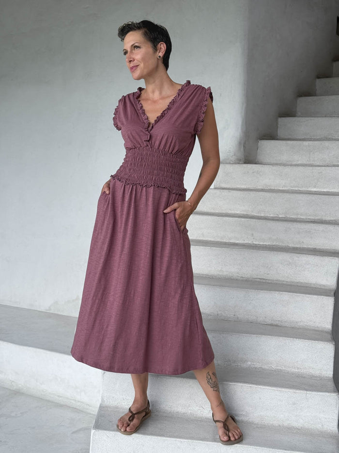 caraucci pink midi-length dress with smocked waist and sleeveless ruffled neckline and pockets #color_mangosteen