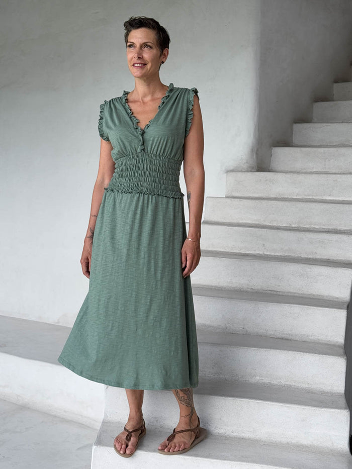 caraucci matcha green midi-length dress with smocked waist and sleeveless ruffled neckline and pockets #color_matcha