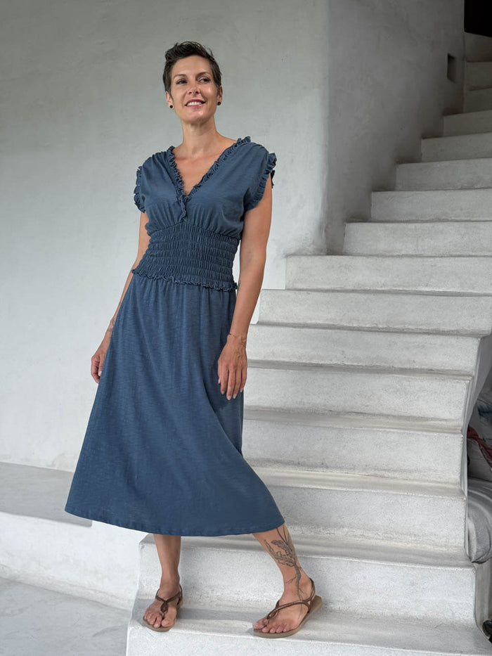 caraucci blue midi-length dress with smocked waist and sleeveless ruffled neckline and pockets #color_pacific