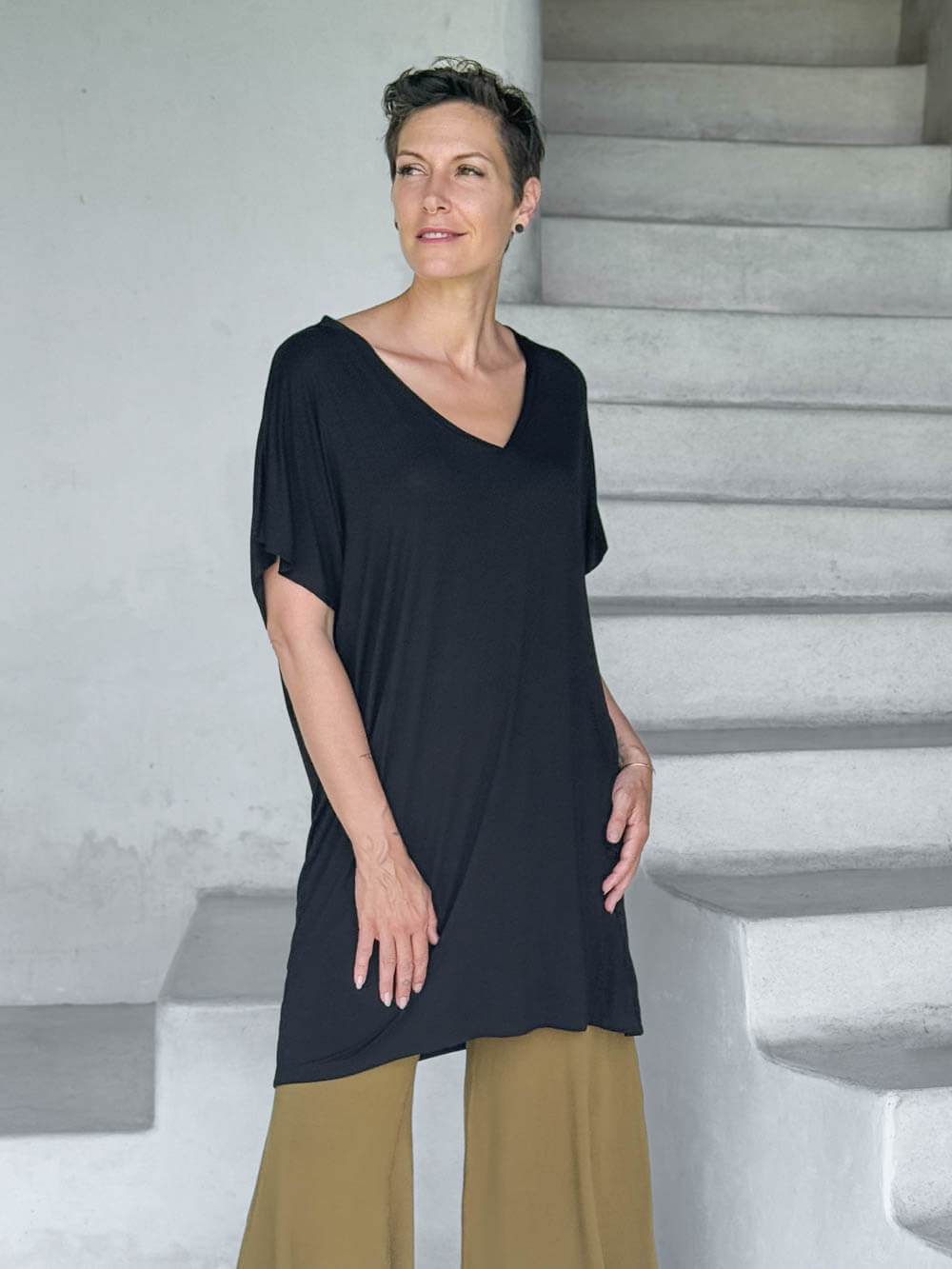 caraucci-woman-wearing-black-v-neck-tunic-and-brass-wide-leg-pants #color_black