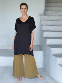 caraucci-woman-wearing-black-v-neck-tunic-and-brass-wide-leg-pants #color_black