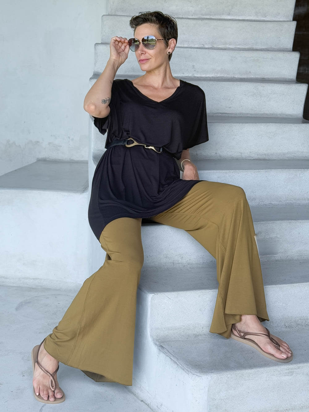 caraucci-woman-wearing-black-v-neck-tunic-and-brass-wide-leg-pants #color_black