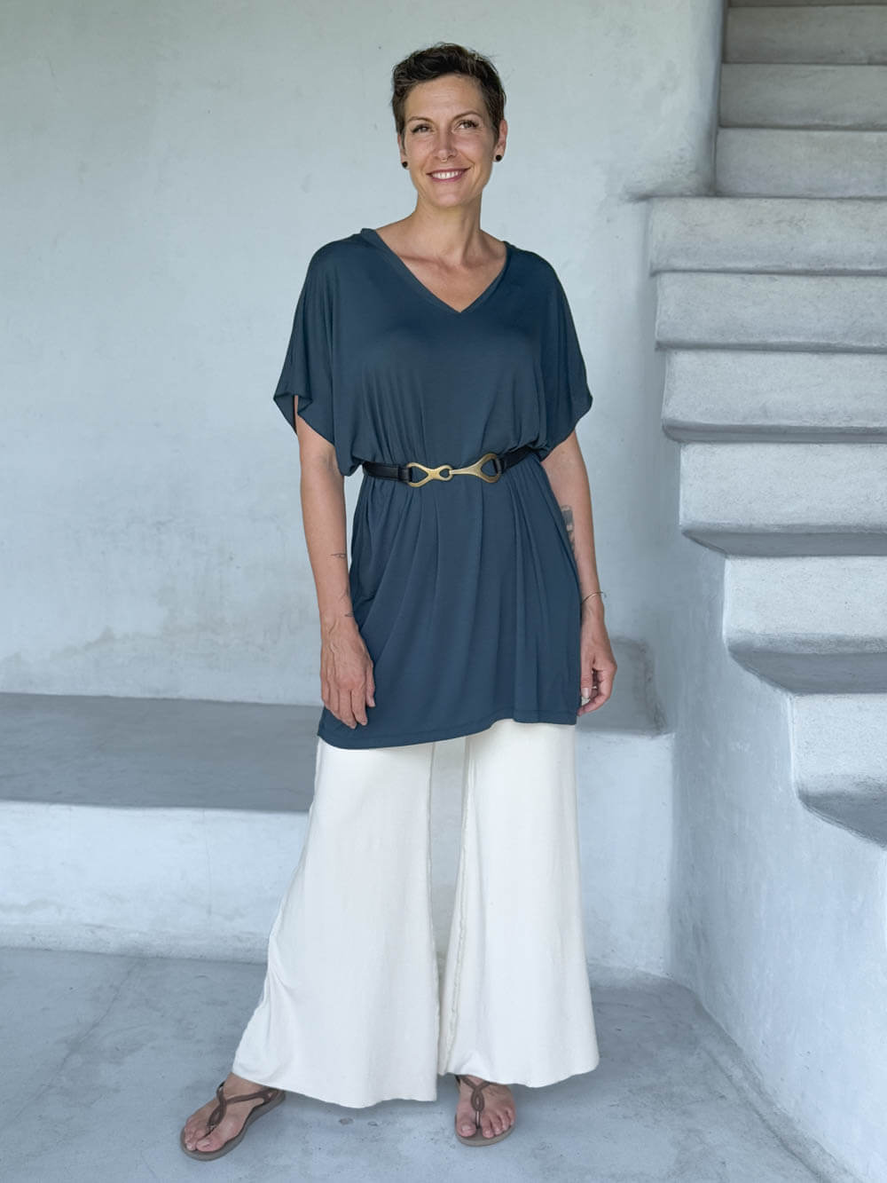 caraucci-woman-wearing-teal-v-neck-tunic- with-belt-and-cream-wide-leg-pants #color_teal