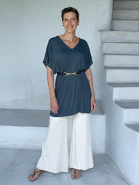caraucci-woman-wearing-teal-v-neck-tunic- with-belt-and-cream-wide-leg-pants #color_teal