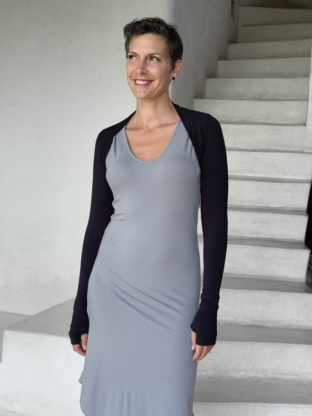 caraucci-woman-wearing-black-sleeve-shrug-layered-over-grey-dress-with-thumbhole-detail #color_black