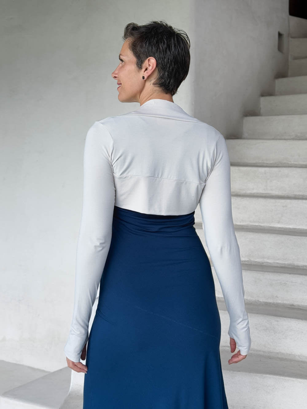 caraucci-woman-wearing-white-sleeve-shrug-layered-over-navy-dress-with-thumbhole-detail #color_off-white