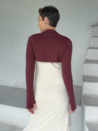 caraucci-woman-wearing-maroon-sleeve-shrug-layered-over-cream-dress-with-thumbhole-detail #color_wine
