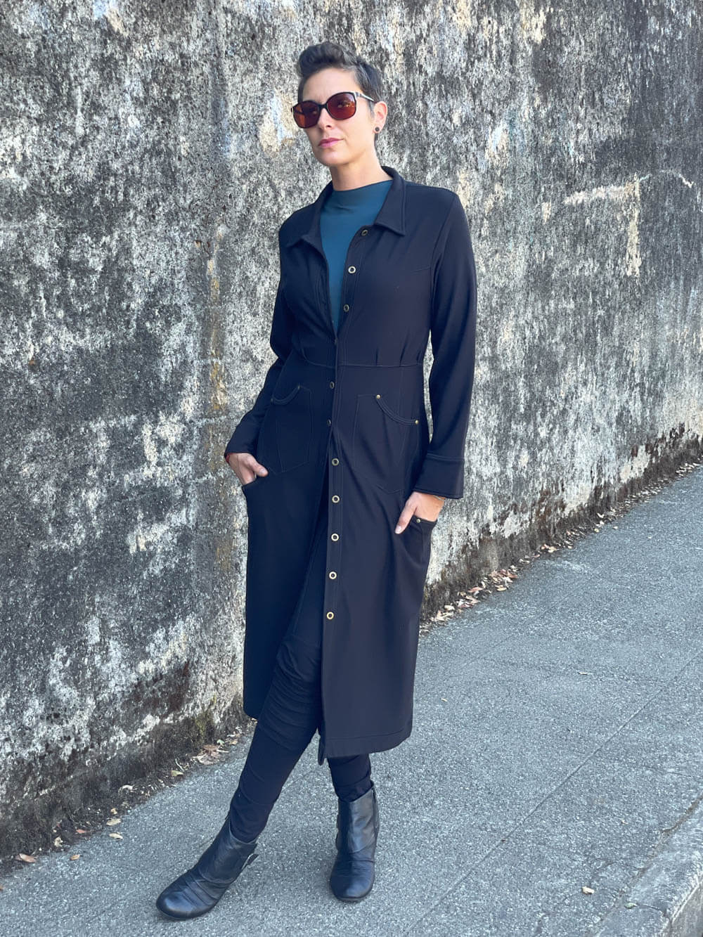 caraucci bamboo spandex black coat dress with 6 pockets and brass buttons up the front, can be worn as a jacket or dress #color_black