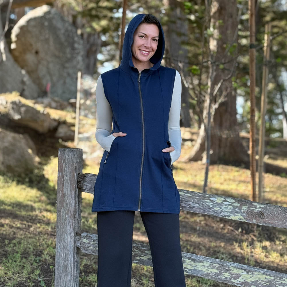 Woman wearing a navy CARAUCCI bamboo cotton fleece layer with black bamboo pants.