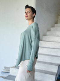 caraucci plant-based rayon jersey sage green asymmetrical hem oversized long sleeve top with thumbholes #color_moss