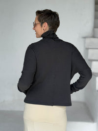 caraucci black bamboo fleece jacket, shown buttoned into a high cowl neck, from the back, with thumbholes and pockets #color_black
