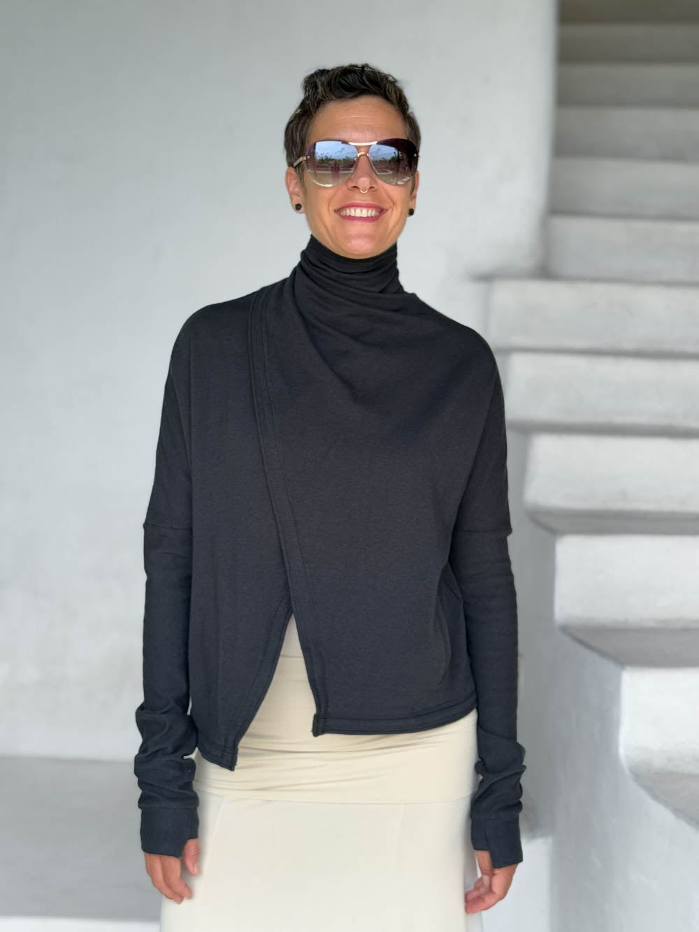 caraucci black bamboo fleece jacket, shown buttoned into a high cowl neck with thumbholes and pockets #color_black