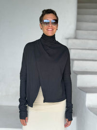 caraucci black bamboo fleece jacket, shown buttoned into a high cowl neck with thumbholes and pockets #color_black