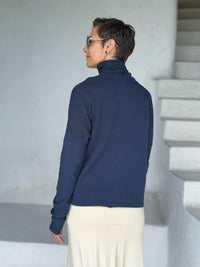 caraucci navy blue bamboo fleece jacket, shown buttoned into a high cowl neck with thumbholes and pockets #color_navy