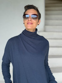 caraucci navy blue bamboo fleece jacket, shown buttoned into a high cowl neck with thumbholes and pockets #color_navy