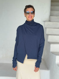caraucci navy blue bamboo fleece jacket, shown buttoned into a high cowl neck with thumbholes and pockets #color_navy