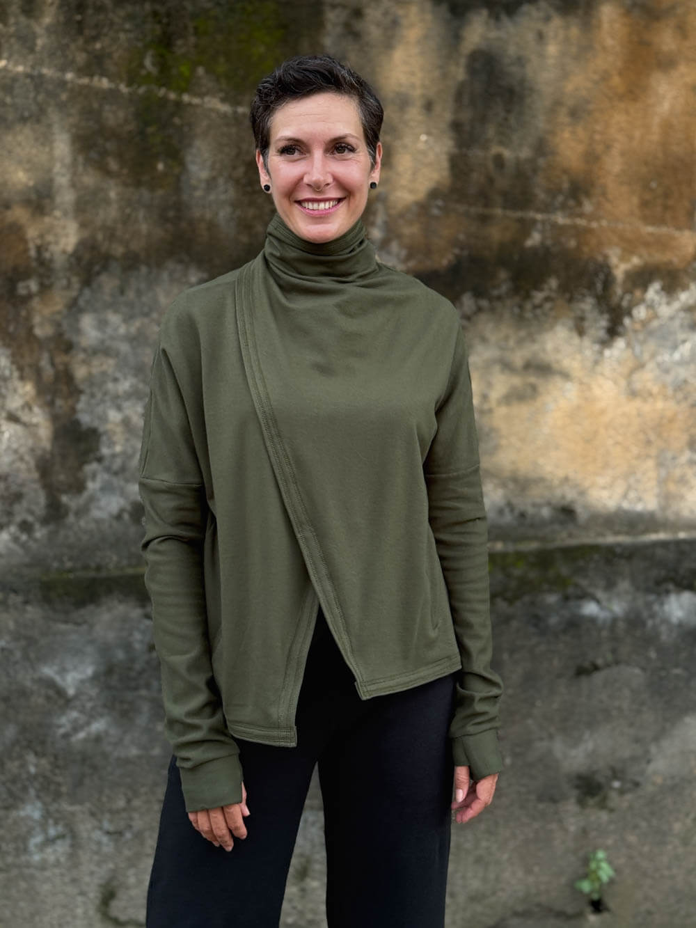 caraucci forest green bamboo fleece jacket, shown buttoned into a high cowl neck with thumbholes and pockets #color_forest