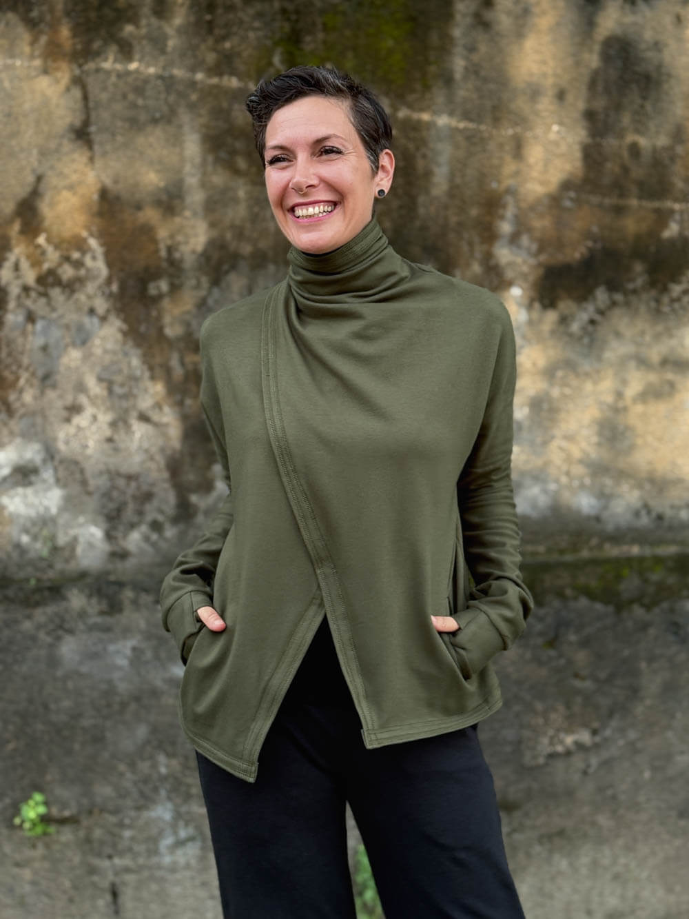 caraucci forest green bamboo fleece jacket, shown buttoned into a high cowl neck with thumbholes and pockets #color_forest