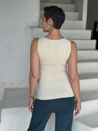 caraucci-woman-wearing-cream-boat-neck-tank-top-in-rayon-jersey-layered-over-teal-skirt-pants #color_cream