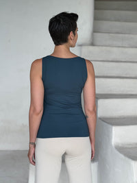 caraucci-woman-wearing-teal-boat-neck-tank-top-in-rayon-jersey-layered-over-cream-pants #color_teal