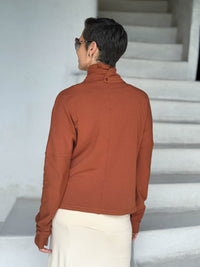caraucci orange bamboo fleece jacket, shown from the back, buttoned into a high cowl neck with thumbholes and pockets #color_copper