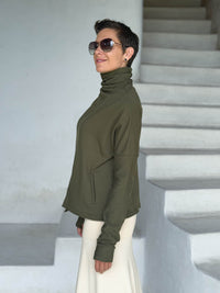 caraucci forest green bamboo fleece jacket, shown buttoned into a high cowl neck with thumbholes and pockets #color_forest