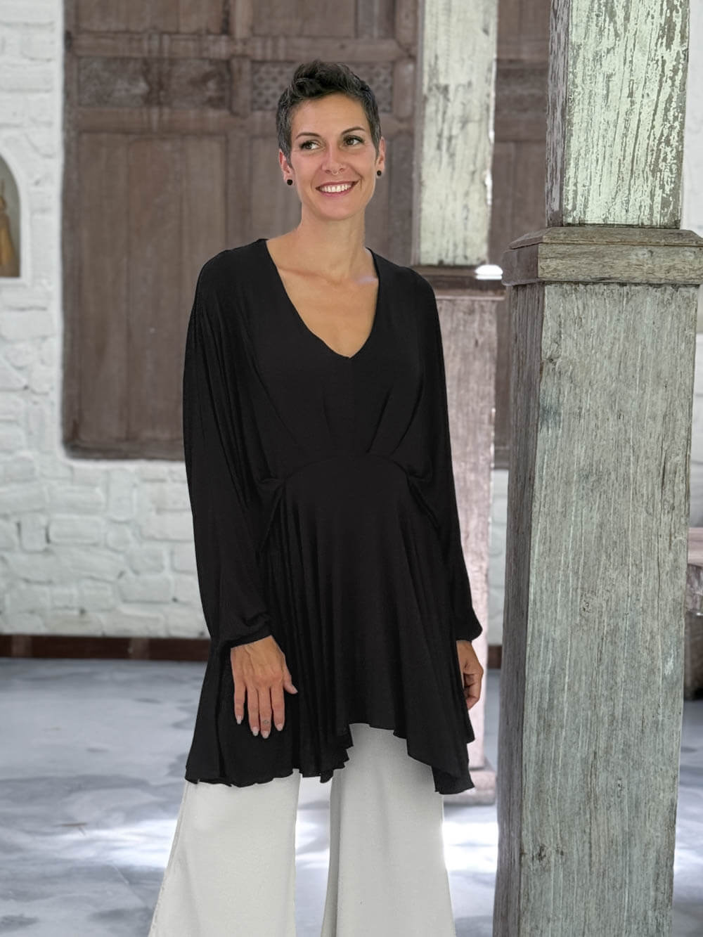 caraucci peplum tunic in black lightweight rayon jersey with v neckline and asymmetrical hem #color_black