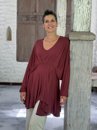 caraucci peplum tunic in maroon lightweight rayon jersey with v neckline and asymmetrical hem #color_wine