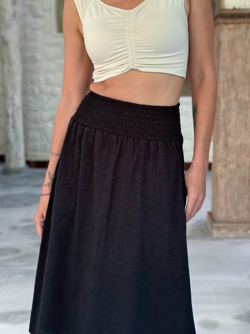 caraucci siena midi skirt in black cotton smocked waist midi skirt with pockets #color_black