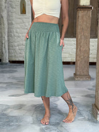 caraucci siena midi skirt in soft sage green cotton smocked waist midi skirt with pockets #color_matcha
