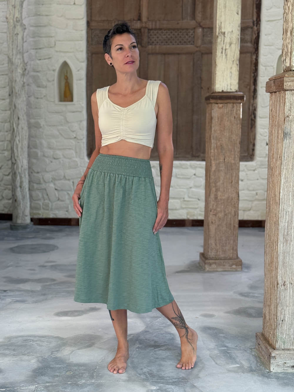 caraucci siena midi skirt in soft sage green cotton smocked waist midi skirt with pockets #color_matcha