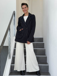 CARAUCCI Urban Lounge unstructured double-breasted black Bamboo Fleece jacket shown with cream flare pants #color_black