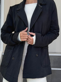 CARAUCCI Urban Lounge unstructured double-breasted black Bamboo Fleece jacket shown with cream flare pants #color_black