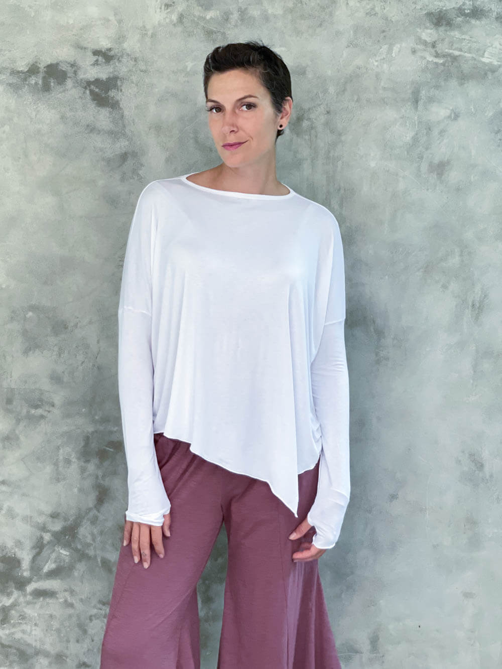 caraucci plant-based rayon jersey white asymmetrical hem oversized long sleeve top with thumbholes #color_white